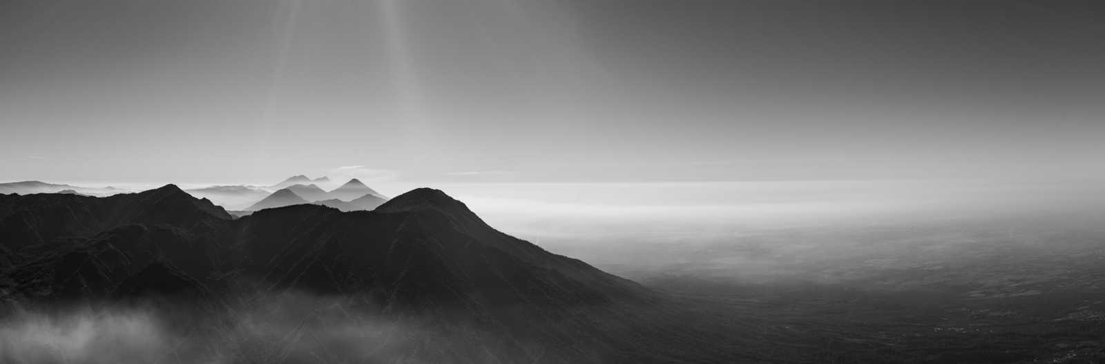 A black and white panorama view of a row of volcanoes